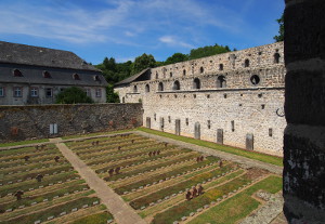 Blick über den Kriegsopferfriedhof auf Kirchenruine und Bursenbau